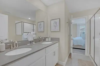 a white bathroom with two sinks and a shower at Ev4568 - Storey Oasis in Kissimmee