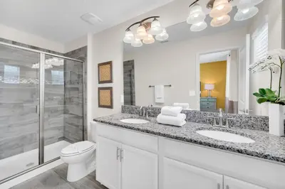 a bathroom with a toilet and two sinks and a shower at Ev4710 - Regal Villa in Kissimmee