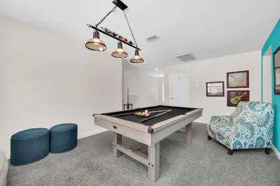a room with a pool table and a chair at Ev4710 - Regal Villa in Kissimmee