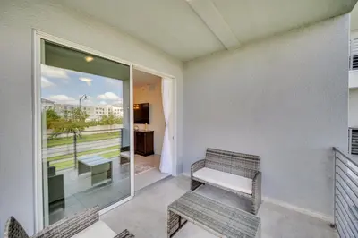 a balcony with two chairs and a bench and a window at Ev208 - The Storey Condo in Kissimmee