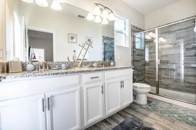 a white bathroom with a shower and a toilet at Ev4755 - Tranquil Haven Villa in Kissimmee