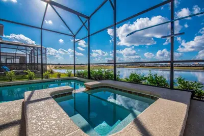 a swimming pool in a building with a view of the water at Ev4755 - Tranquil Haven Villa in Kissimmee