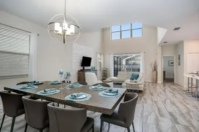a dining room and living room with a table and chairs at Ev4778 - Paradise Cove Villa in Kissimmee