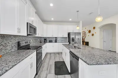 a kitchen with white cabinets and granite counter tops at Ev4795 - Kings Oasis in Kissimmee