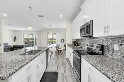 a kitchen with white cabinets and marble counter tops at Ev4795 - Kings Oasis in Kissimmee