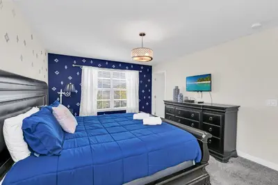 a bedroom with a blue bed and a dresser at Ev4795 - Kings Oasis in Kissimmee