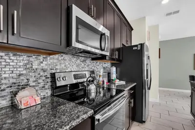 a kitchen with black cabinets and a stove top oven at Ev4804 - Starlight Retreat in Kissimmee