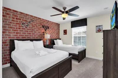 a bedroom with two beds and a brick wall at Ev4804 - Starlight Retreat in Kissimmee