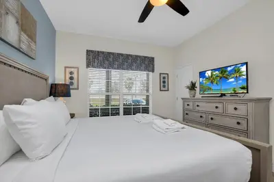 a bedroom with a white bed and a flat screen tv at Ev4804 - Starlight Retreat in Kissimmee