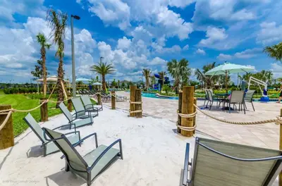 a patio with chairs and tables and a pool at 4811Ll Amazing 5 Bedroom 4 Bathroom in Kissimmee
