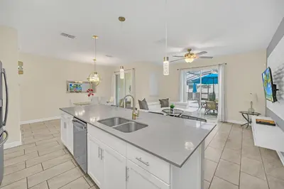a kitchen with a sink and a living room at Ev4927 - Beautiful Storey Lake in Kissimmee
