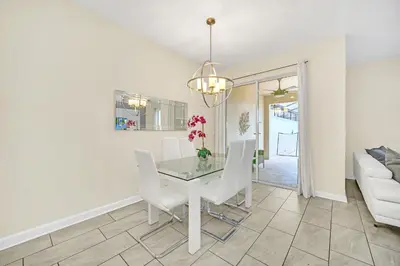 a dining room with a glass table and white chairs at Ev4927 - Beautiful Storey Lake in Kissimmee