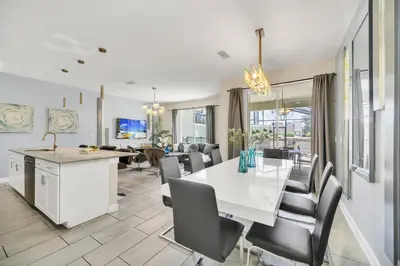 a dining room and living room with a white table and chairs at Ev4987 - Raceway Retreat in Kissimmee