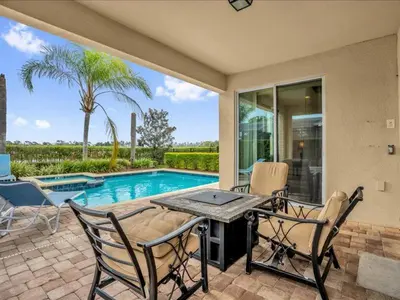 a patio with a table and chairs and a pool at Ev7501 - Encore in Orlando
