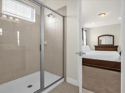 a bathroom with a glass shower and a bed at Ev7501 - Encore in Orlando