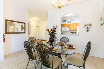 a dining room with a glass table and chairs at Ev76604 - Windsor Condo in Orlando