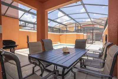 a dining room with a table and chairs and a pool at Ev89270 - Paradise Manor in Kissimmee