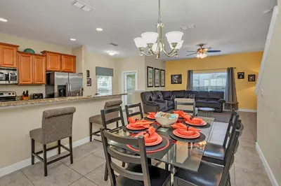 a dining room and kitchen with a table and chairs at Ev8950 - Paradise Oasis Villa in Kissimmee