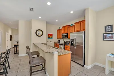 a kitchen with wooden cabinets and a counter top at Ev8950 - Paradise Oasis Villa in Kissimmee