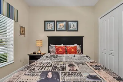 a bedroom with a bed with a newspaper bedspread at Ev8950 - Paradise Oasis Villa in Kissimmee
