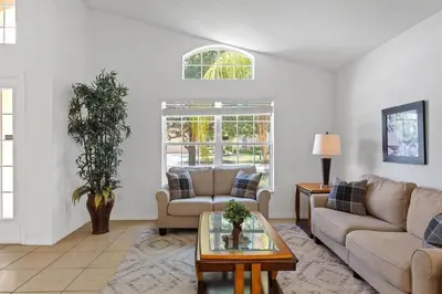 a living room with two couches and a table at Casa 4Q c/ Piscina & Spa no Veranda Palms in Kissimmee