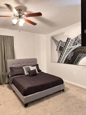 a bedroom with a bed and a ceiling fan at Beautiful 5BR home near Disney with private pool, large yard & BBQ in Orlando