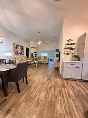 a large living room with a table and a kitchen at Beautiful 5BR home near Disney with private pool, large yard & BBQ in Orlando