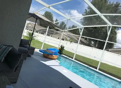 a swimming pool in front of a building at Beautiful 5BR home near Disney with private pool, large yard & BBQ in Orlando