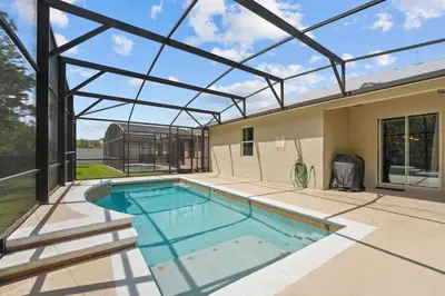 an indoor swimming pool with a glass roof at 4 Bed Close to Disney Private Pool in Kissimmee
