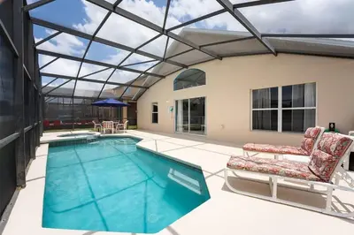 a swimming pool with a glass ceiling and two chairs at Casa Térrea 4Q c/ Piscina e Game Room in Kissimmee