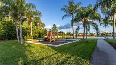a playground in a park with palm trees at Casa Térrea 4Q c/ Piscina e Game Room in Kissimmee