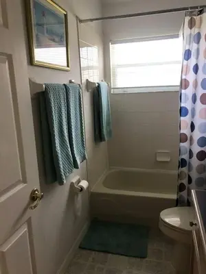 a bathroom with a bath tub and a toilet at Indian Creek 4bd Pool in Orlando