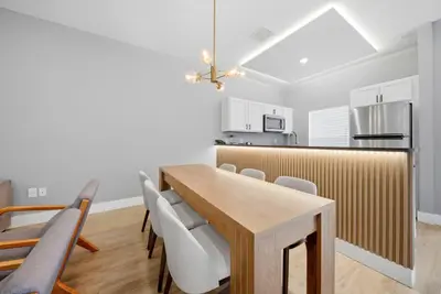 a kitchen and dining room with a wooden table and chairs at NEW Cozy 2 Bedrooms2Baths At Encantada in Kissimmee