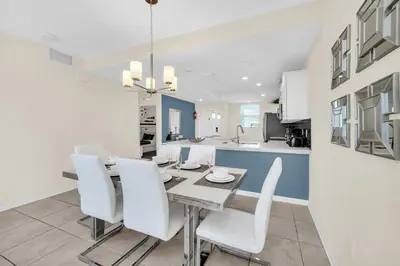 a kitchen and dining room with a table and white chairs at Ev4721C304 - Sunset Nest in Kissimmee