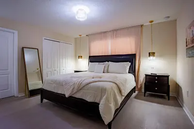 a bedroom with a large bed and a dresser and a mirror at 8952 Private pool 4bd townhome in Kissimmee