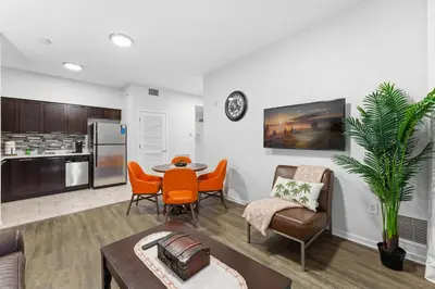 a living room with a table and chairs and a kitchen at Orlando Getaway with Pool View Balcony in Orlando