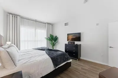 a bedroom with a bed and a dresser and a window at Orlando Getaway with Pool View Balcony in Orlando