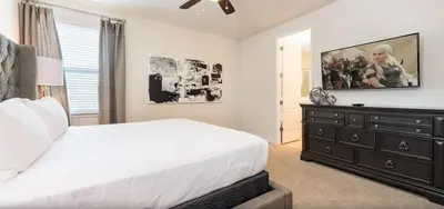 a bedroom with a large white bed and a dresser at Ultimate Mansion-9Bed-PoolSpaGame in Orlando