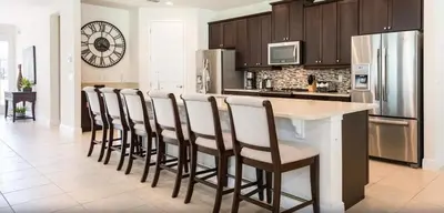 a kitchen with a counter and a bar with chairs at Ultimate Mansion-9Bed-PoolSpaGame in Orlando