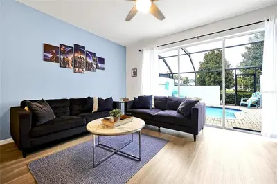 a living room with a couch and a table at Windsor Hills Marvel Themed Home with Private Pool in Orlando