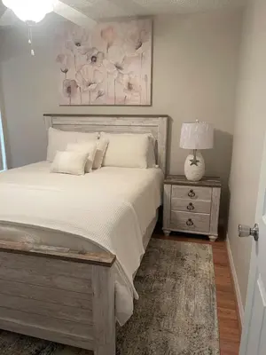 a bedroom with a bed and a table with a lamp at 