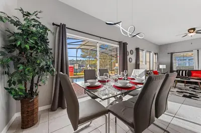 a dining room with a glass table and chairs at 3179 Yellow Lantana Lane in Kissimmee