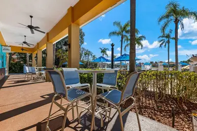 a patio with a table and chairs and palm trees at 3179 Yellow Lantana Lane in Kissimmee