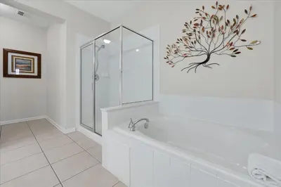 a white bathroom with a shower and a bath tub at Beautiful Condo, Near Epic Universe and OCCC-2018 by Vista Cay Resort in Orlando