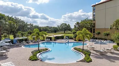 a pool at a resort with chairs and a building at Orange Lake Vacation Time in Orlando