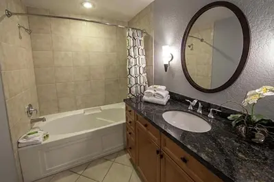 a bathroom with a sink and a tub and a mirror at Orange Lake Vacation Time in Orlando