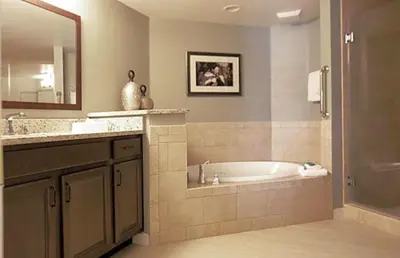 a bathroom with a tub and a sink and a mirror at Orange Lake Vacation Time in Orlando