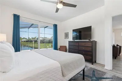 a bedroom with a large bed and a large window at Disney World, Universal Epic Waterfront Modern Home - Private Pool And Game Room in Kissimmee