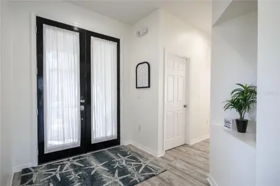 a hallway with white walls and a black door at Disney World, Universal Epic Waterfront Modern Home - Private Pool And Game Room in Kissimmee