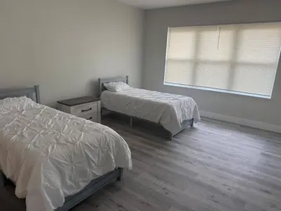 a bedroom with two beds and a window at Lakefront Luxury w Private Dock Sunrises in Orlando